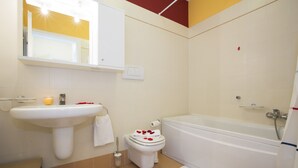 Een badkamer met een wastafel, toilet en bad.