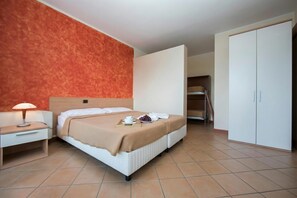 A hotel room with a bed, bedside table, lamp, and wardrobe. - Porto Letizia S14, Porlezza, Italy (Porlezza)