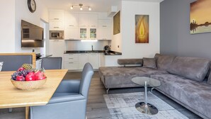 Een moderne leefruimte met een eethoek, bank en keuken.