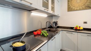 Een moderne keuken met roestvrijstalen apparatuur, een zwart aanrecht en witte kasten.
