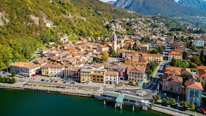 Eine Stadt mit einem Fluss, Gebäuden und Bergen im Hintergrund.