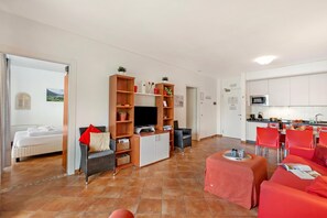 Una sala de estar moderna con televisor, sofá y zona de comedor.