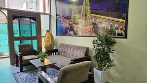 Una habitación con sofá, sillas, una mesa y una planta en maceta.