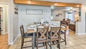 A dining area with a wooden table set for four, surrounded by wooden chairs. A sign on the wall reads "THE GATHERING PLACE." - Family-Friendly Sanctuary: BBQ, Patio & Yard (Oak Hill)