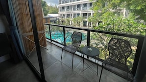 Ein Balkon mit Pool, Stühlen und Blick auf ein mehrstöckiges Gebäude.