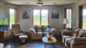 A living room with a sofa, armchairs, a coffee table, and a television. - 3 miles from Sunburst Ski Hill. Close to  great hikiing and snow mobile trails (Kewaskum)