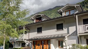 A two-story building with a wooden front door and a balcony.