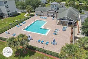 A swimming pool surrounded by lounge chairs and umbrellas, with a building in the background. - 3176-301 Resort 2BR Apt by Disney World Orlando (Kissimmee)