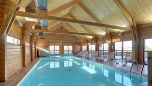 An indoor swimming pool with wooden walls and ceiling, surrounded by lounge chairs. - Chalet in La Joue du Loup, sleeps 6, terrace, parking (La Joue du Loup)