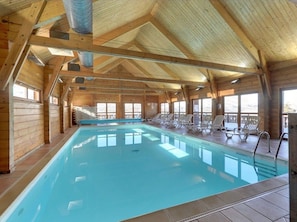 An indoor swimming pool with wooden walls and ceiling, surrounded by lounge chairs. - Chalet in La Joue du Loup, sleeps 6, terrace, parking (La Joue du Loup)