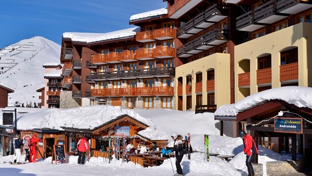 A ski resort with multi-story buildings, ski slopes, and a snow-covered mountain in the background. - Functional studio 3/4 pers with balcony and direct slopes access (Belle Plagne)