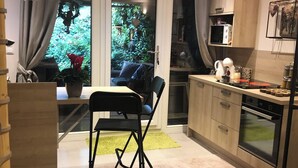 Una cucina moderna con zona pranzo, un'ampia finestra vista su spazi verdi e un angolo relax.