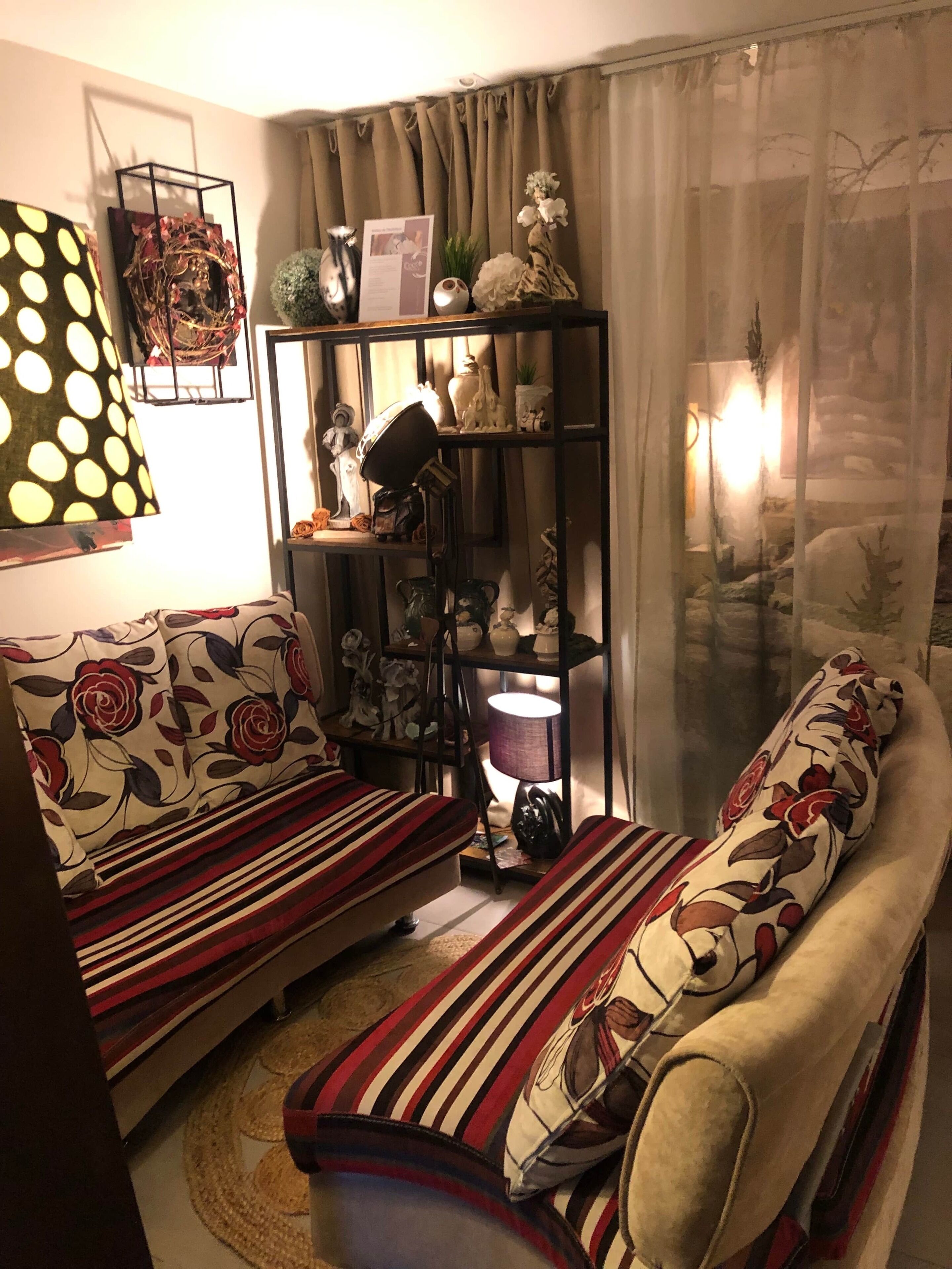 Un accogliente soggiorno con un divano e un tavolino, una libreria con oggetti decorativi e un tappeto decorato.