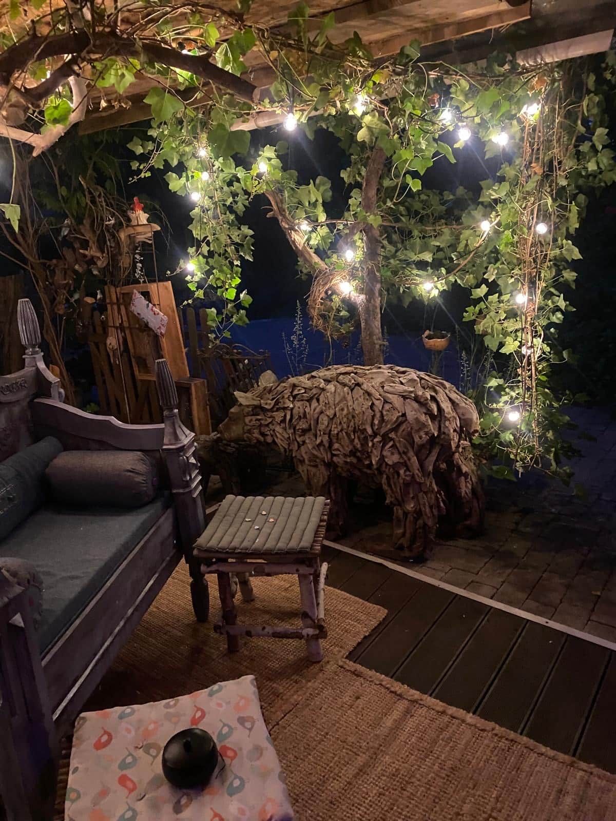 A cozy outdoor seating area with a sofa, a small table, and a bench.