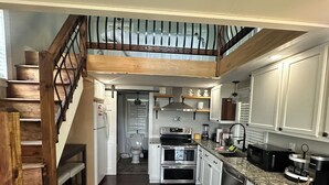A spacious kitchen with wooden floors, white cabinets, and a built-in oven. - Lakeview Getaway with Stunning Sunsets with lake access (Newport)