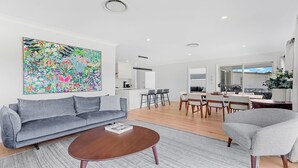 A modern living room with a gray sofa, a coffee table, and a colorful abstract painting.