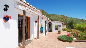A white building with terracotta roof tiles, a tiled patio, and potted plants. - Romantic and private hide away with pool in Andalusia. (Comares)