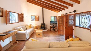 A cozy living room with a fireplace, a television, and a sofa. - Romantic and private hide away with pool in Andalusia. (Comares)
