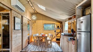 Uma cozinha compacta com área de refeições, paredes de madeira e um tapete estampado.