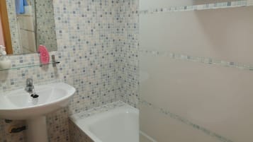Bathtub, hair dryer, towels, toilet paper