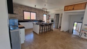Una cocina moderna con una isla central, dispensador de agua y refrigerador.