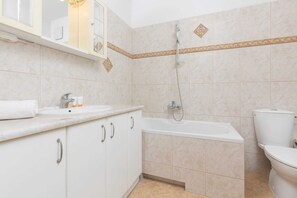 Bañera, secador de pelo, toallas, shampoo
