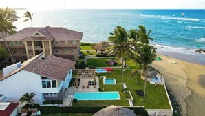 Una propiedad frente a la playa con piscina, un edificio grande y una playa.