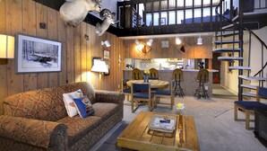 A cozy living room with a patterned sofa, a wooden coffee table, and a spiral staircase. - Home Away From Home! Ski-in/Ski-out, Dog Friendly Condo w/ Fireplace & Views (Mt. Crested Butte)