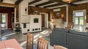 Un intérieur rustique avec des poutres apparentes, une cheminée et un coin salon confortable.