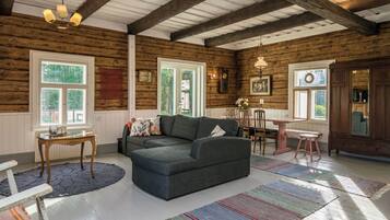 Una sala de estar acogedora con un sofá, una mesa de comedor y una araña.