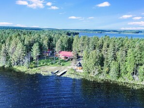 A lakeside property with multiple cabins, a dock, and a forested area.