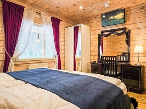 A wooden-paneled room with a bed, a dresser, a mirror, and a window with curtains.