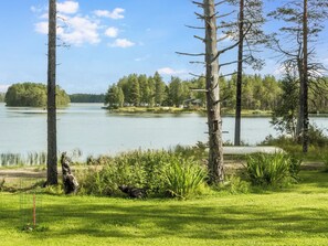 A lakeside property with a grassy area, trees, and a small cabin. - Oravajärven talo (ent. suomela) by Interhome (Ranua)