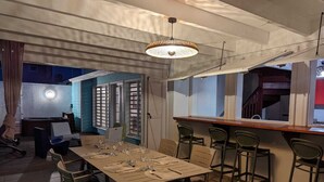 Un comedor con una mesa larga dispuesta para una comida, rodeada de sillas.