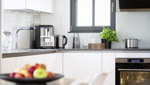 A modern kitchen with a coffee maker, kettle, and a potted plant. - Reetdachhaus in Dranske (Dranske)