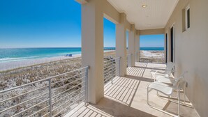 Un balcon avec vue sur la plage et l’océan.