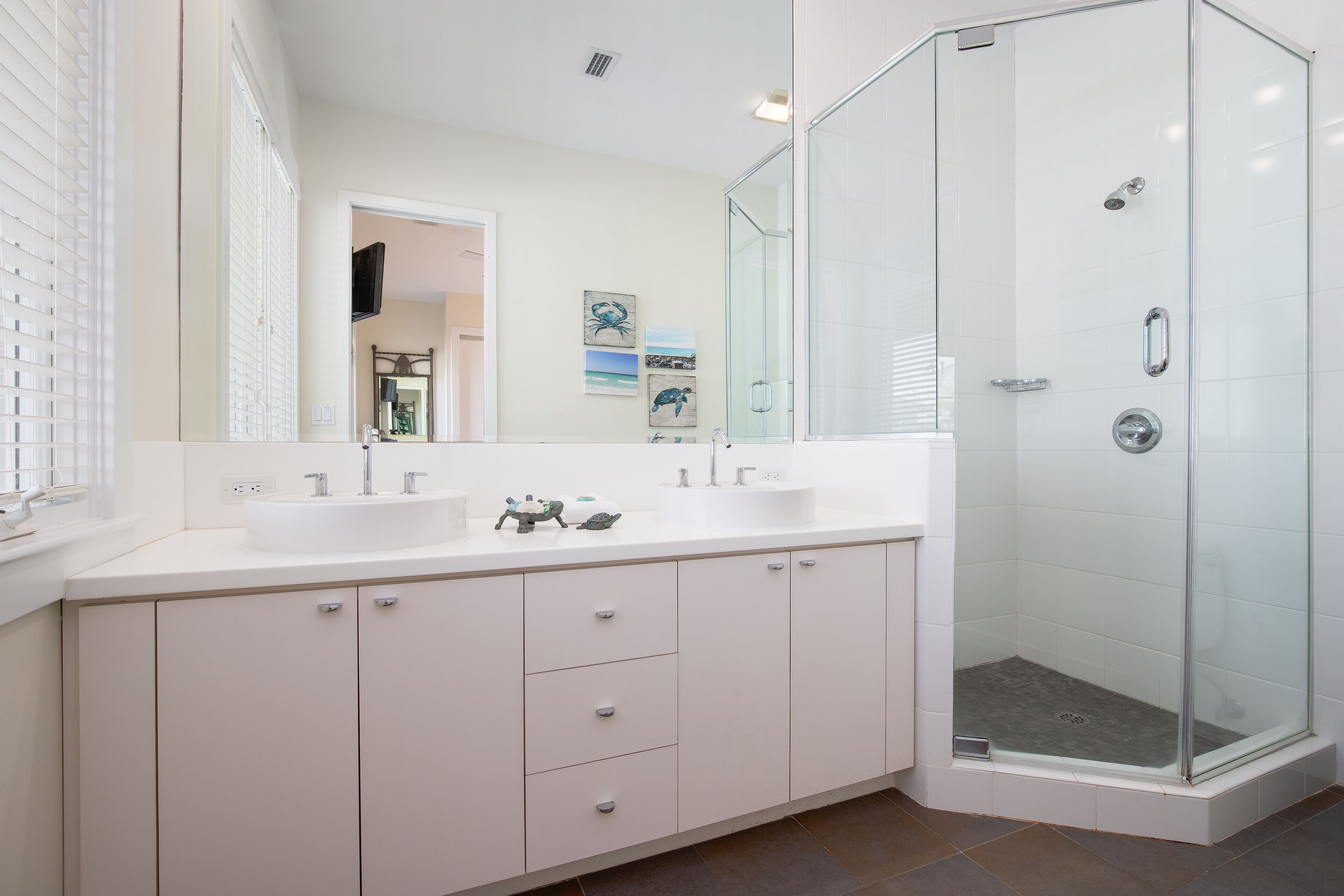 A modern bathroom with a glass-enclosed shower, a double sink vanity, and a large mirror.