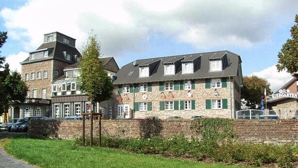 A traditional building with multiple windows and a brick facade, likely a hotel or guesthouse. - Single room (Pulheim)