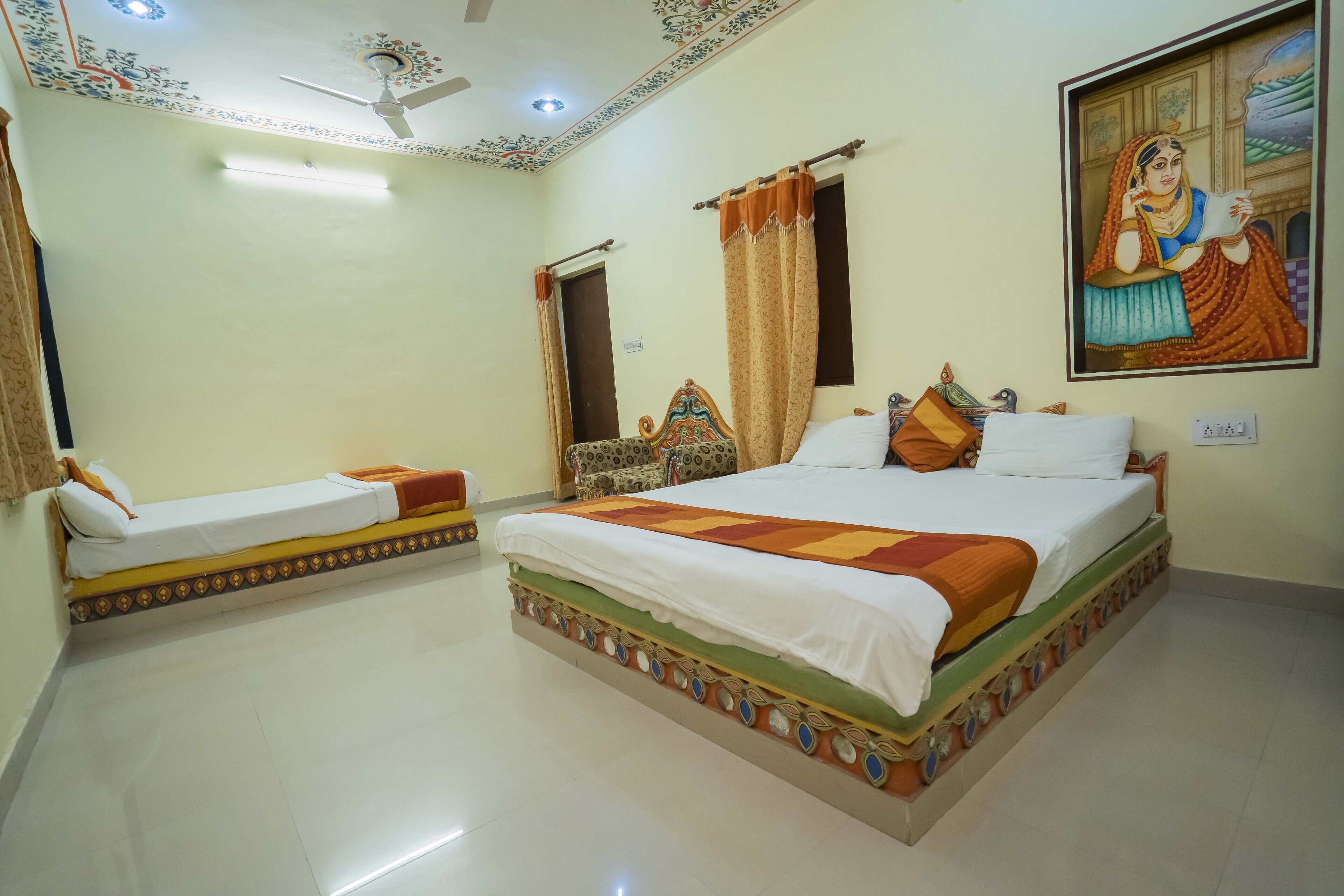 A hotel room with two beds, a ceiling fan, a painting, and a door.