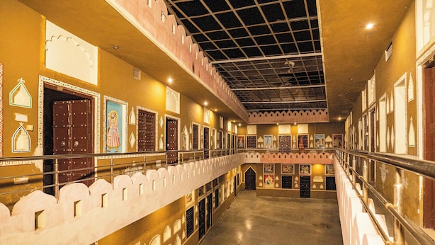 A corridor with ornate doors and railings, suggesting a historic or culturally significant building.