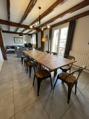A spacious dining area with a long wooden table and chairs, a sofa, and a television in the background. - 350m from ski slopes, 2nd floor, sauna, balcony, ski locker, 130m², Valloire (Valloire)