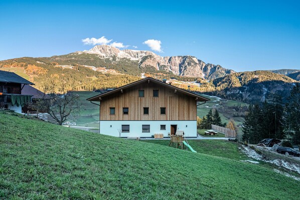 A wooden chalet with a balcony, set against a mountainous backdrop. - Holiday Apartment Mittnackerhof Ringelblume with Mountain View, Balcony & Wi-Fi (Sarentino)