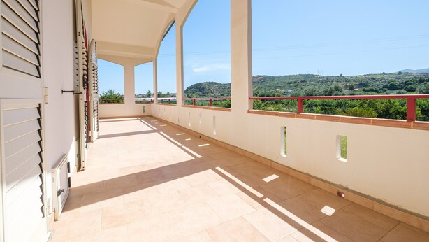 A covered balcony with a view of a green landscape and hills. - Villa "Delle Pomelie" with Private Garden, Balconies, and Wi-Fi (Furnari)