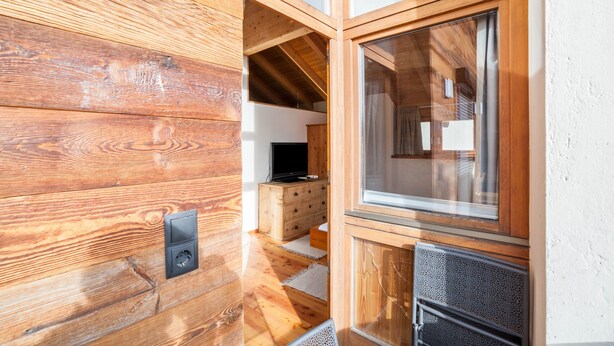 Ein Holzinnenraum mit Fernseher, Holzschränken und einem Fenster.