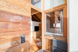 Un intérieur en bois avec une télévision, des meubles en bois et une fenêtre.
