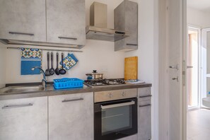 A modern kitchen with a gas stove, oven, and stainless steel cabinets.