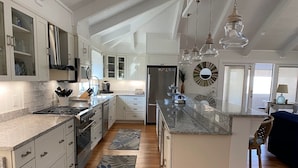 A spacious kitchen with white cabinetry, a central island, and a large island with a sink. -  3 Ensuite Bedrooms - In-town Gem - Walk Everywhere - Sleeps 12 - Private Drive (Rehoboth Beach)