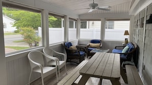 A covered patio with wicker furniture, a wooden table, and a ceiling fan. -  3 Ensuite Bedrooms - In-town Gem - Walk Everywhere - Sleeps 12 - Private Drive (Rehoboth Beach)