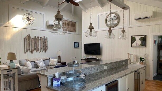 A spacious living area with a large island, wooden flooring, and a ceiling fan. -  3 Ensuite Bedrooms - In-town Gem - Walk Everywhere - Sleeps 12 - Private Drive (Rehoboth Beach)