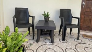 A small outdoor seating area with two chairs and a table, a potted plant, and a tiled floor. - Skyline Suites, Breathtaking Mountains & City View 1 Bedroom Apts by RedAwning (Montego Bay)